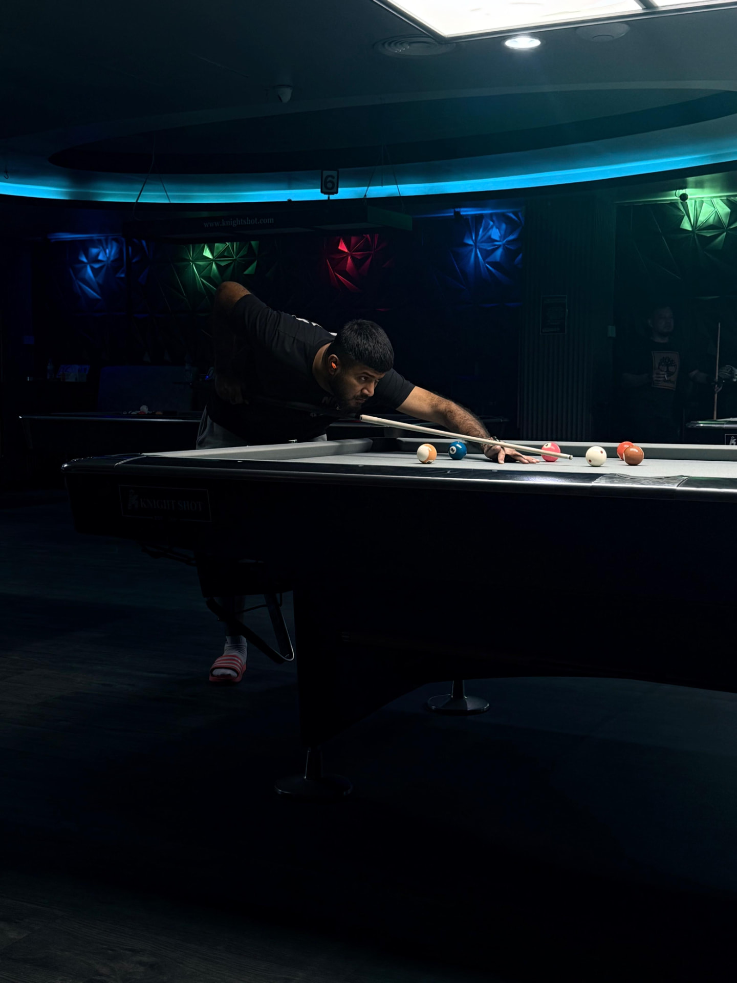 Muhammed Ali, founder of ALIE MARKET, lining up a shot at the pool table